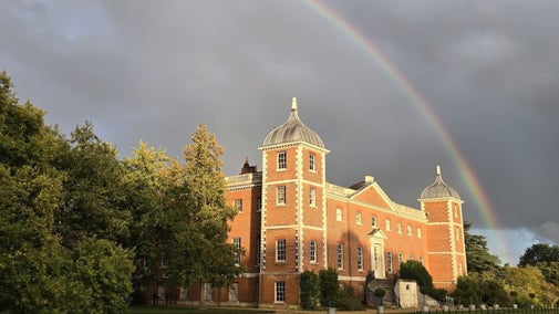 The exterior of Osterley House in west London with dark skies and a rainbow